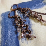 Crystals cascade down antique copper chain