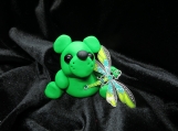 Green bear figurine with a green dragonfly