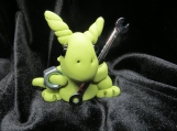 Polymer clay green dragon sculpture with a wrench