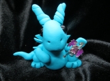Polymer clay turquoise dragon sculpture with a purple minidragon