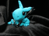 Polymer clay turquoise dragon with a wrench