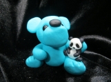 Turquoise bear sculpture with a panda