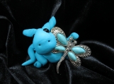 Turquoise polymer clay dragon sculpture with a dragonfly