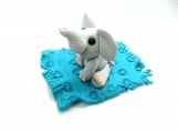Clay elephant on a turquoise blanket baby shower cake topper