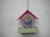 Red, pink and green bird feeder with purple butterfly