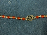 Infinity heart bracelet with red beads and metal spacers