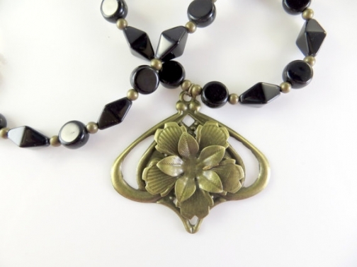 Black and gold beaded necklace with flower.